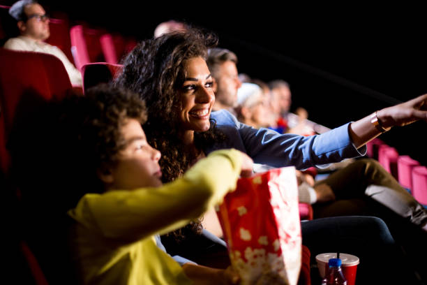 Boy watching movies at the cinema with mother.